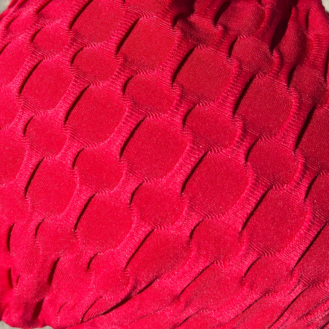 Red textured knit fabric with raised wavy pattern
