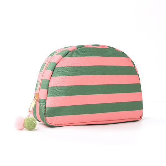 Striped shell makeup bag in green and pink with pom-pom zipper pull.