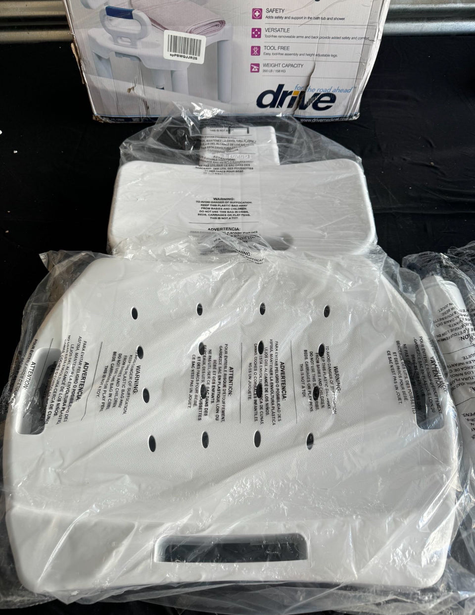 Wrapped white shower chair seat with drainage holes and arm supports