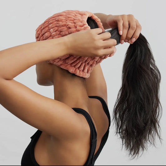 Dusty rose extra-wide spa headband, plush terry texture, being placed on hair