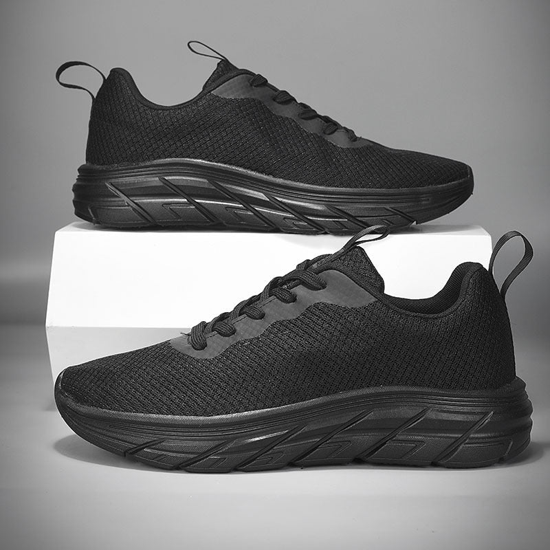 Men's mesh sneakers in black with thick dark sole and lace-up front