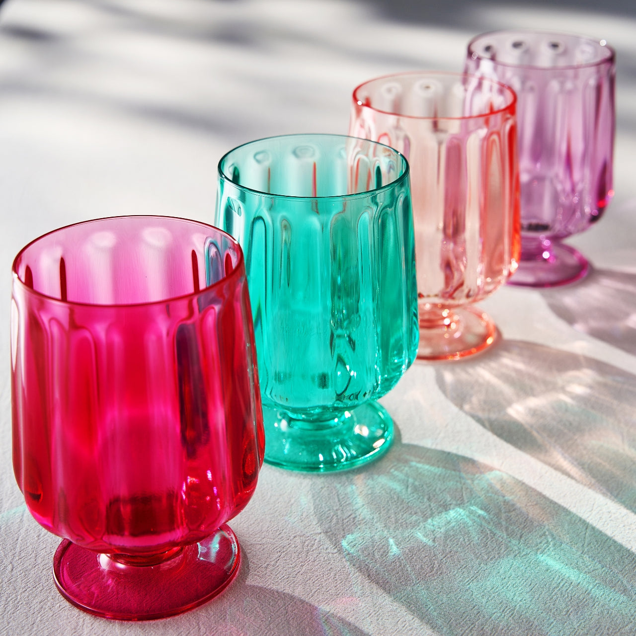 Acrylic stemmed wine goblets in pink, teal, purple, and orange with ridged sides
