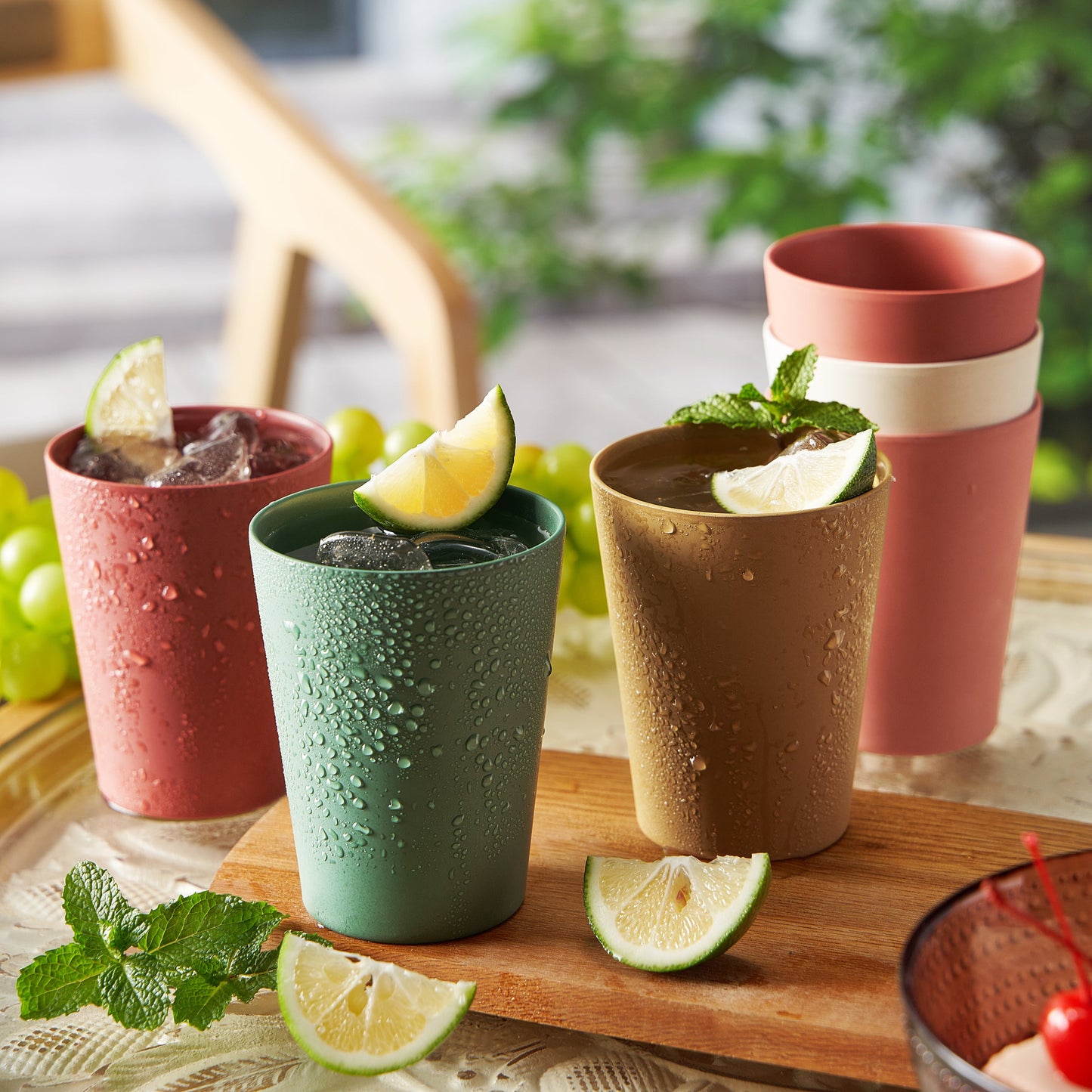 Bamboo tumblers in red, green, tan, and coral, each holding a drink