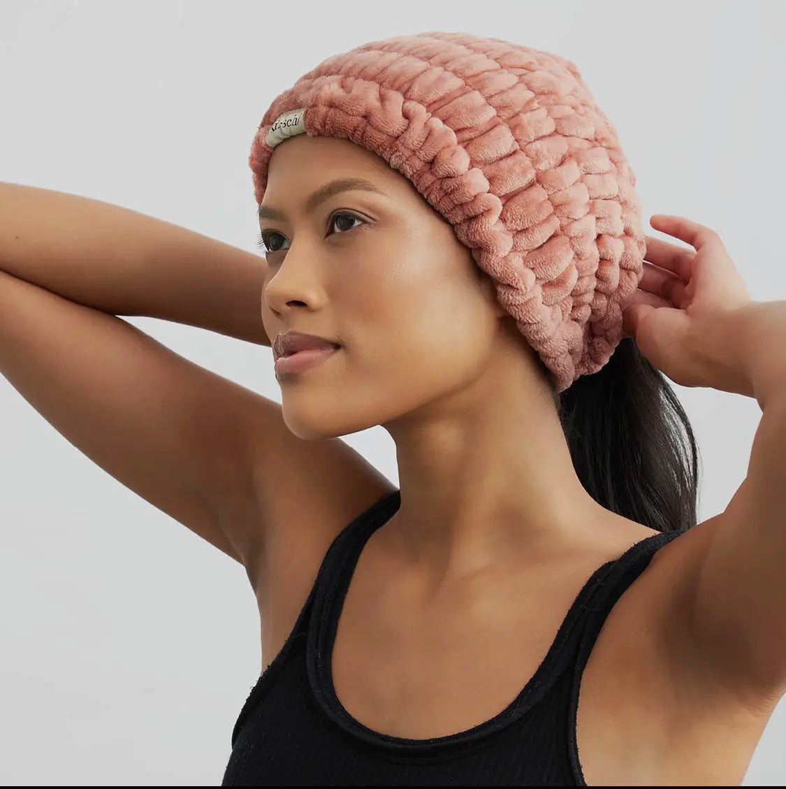 Dusty rose spa headband worn on head, plush terry fabric with folded edge