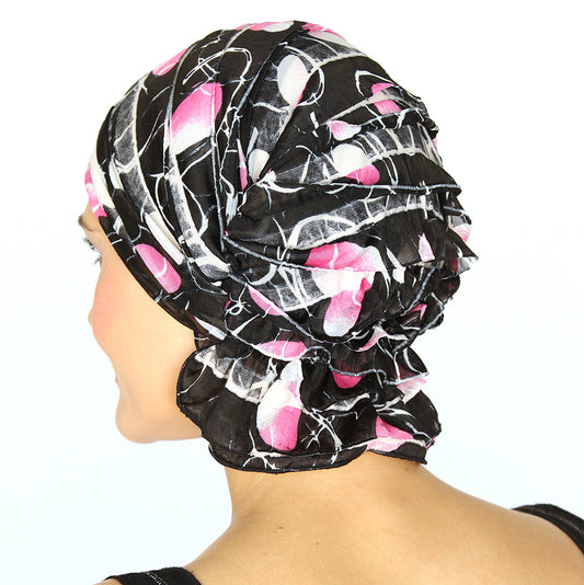 Black chemo beanie side view with pink floral and white web pattern, layered ruffles