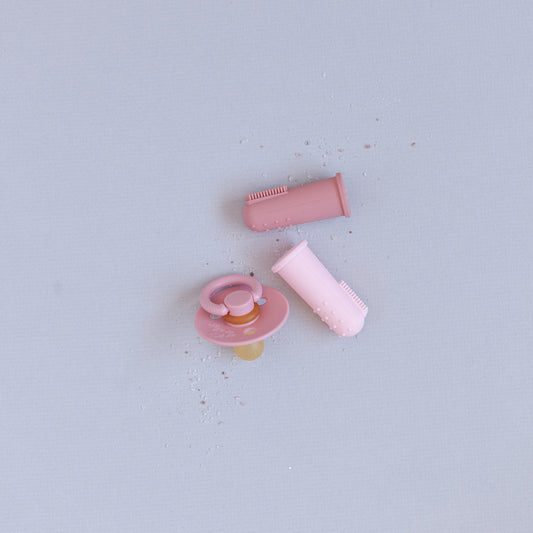 Pink pacifier and its components on a light gray background