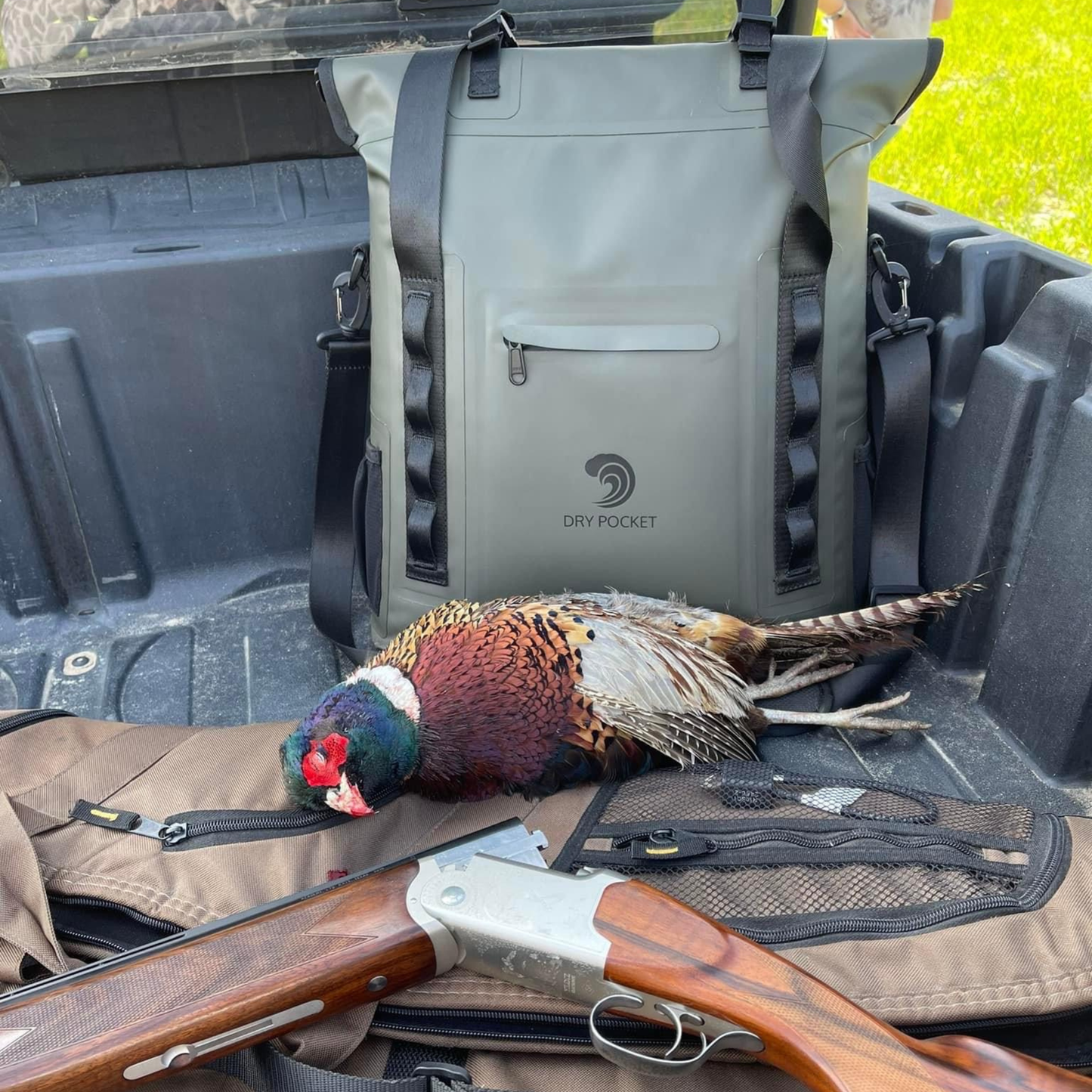 Waterproof floating tote cooler open with gear inside, including a bird and firearm
