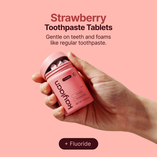 Fluoride strawberry toothpaste tablets container held in a hand