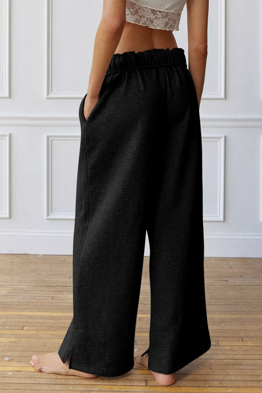 Black high-waist drawstring sweatpants with elastic waistband, wide leg, side view