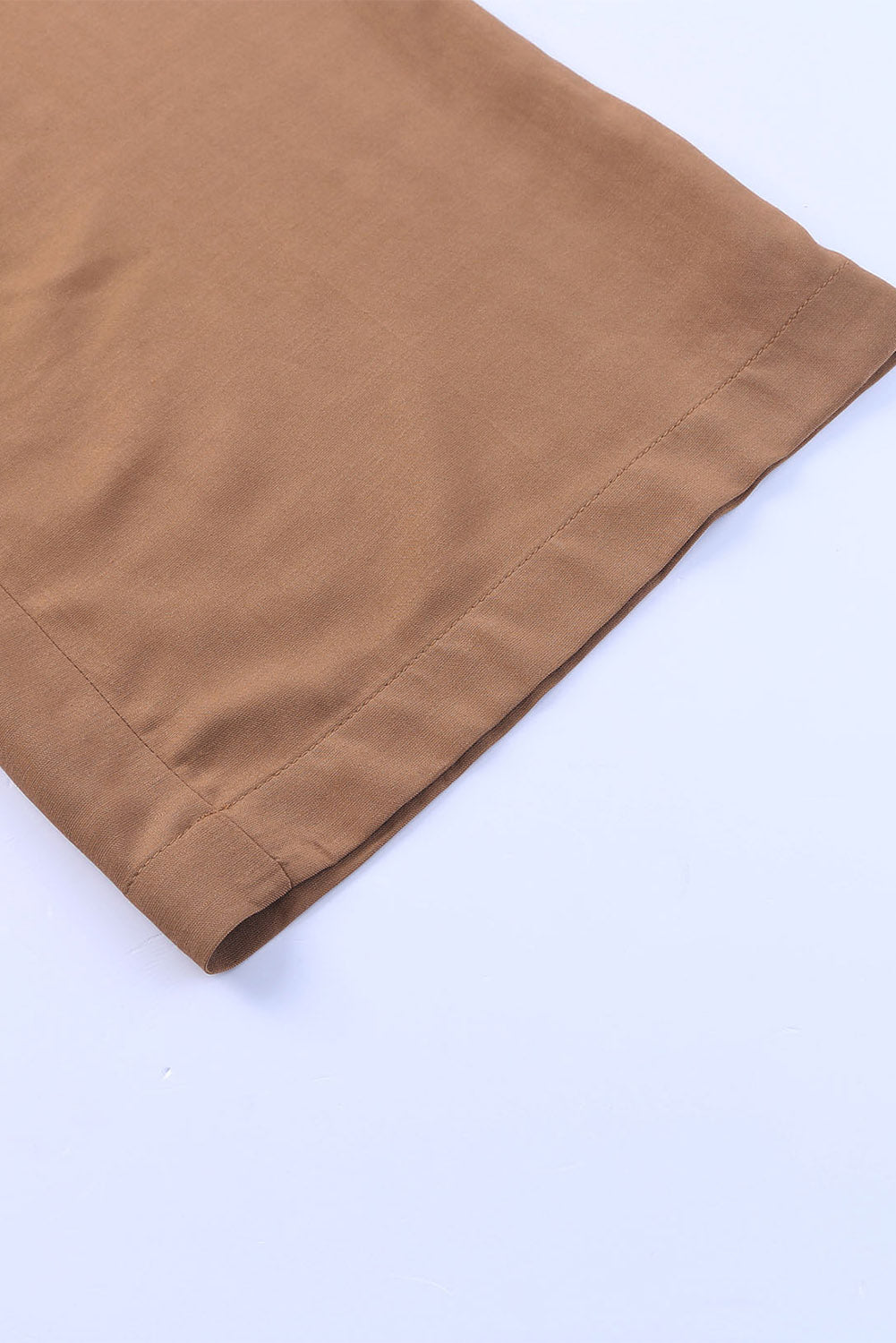 Tan wide-leg pants hem with stitched edge and gathered waistband