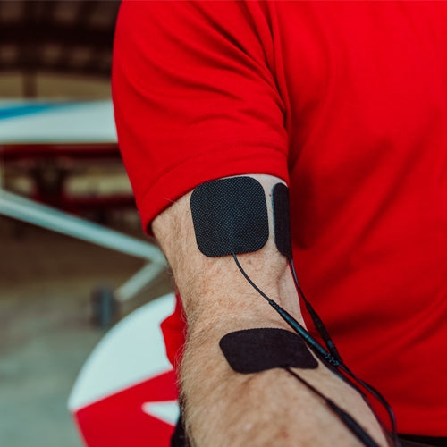 Electrode pads on a man’s arm with connected lead wires on red sleeve