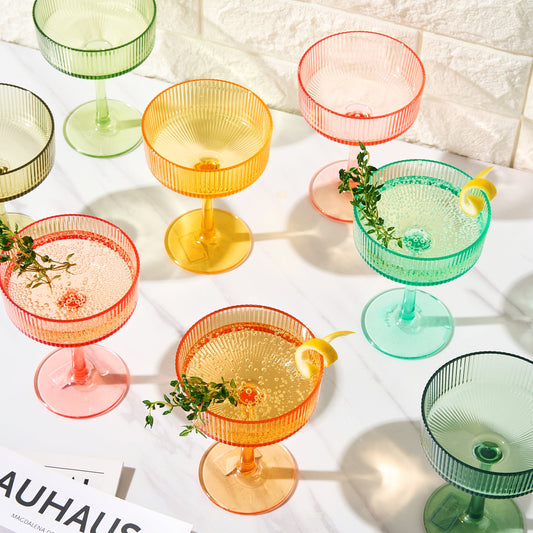 Set of 8 fluted acrylic champagne coupe glasses in assorted pink, green, and amber tones