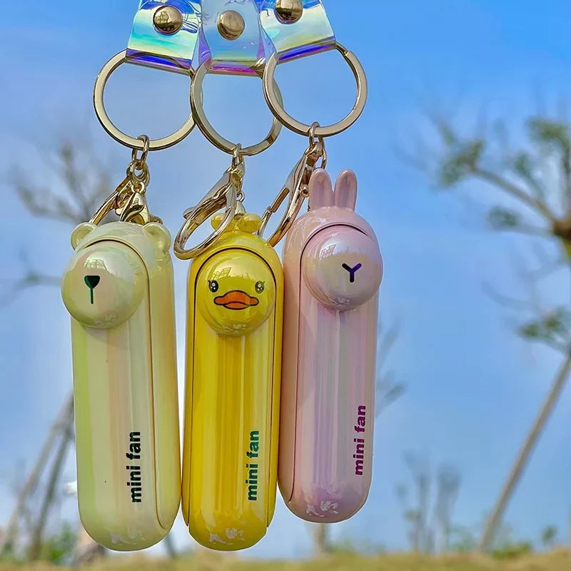 Set of animal-shaped handheld fan keychains in light green, yellow, and pink