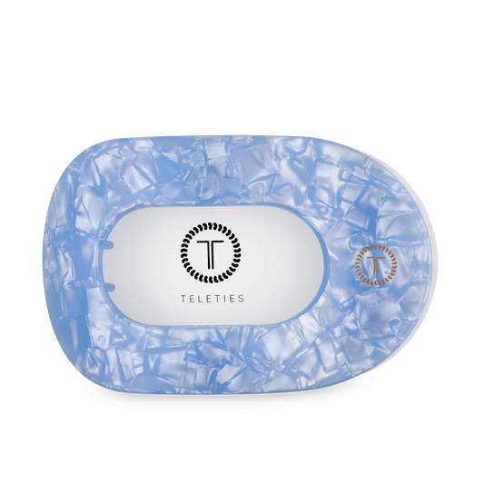 Large light blue flat round hair clip with crinkled finish and TELETIES logo