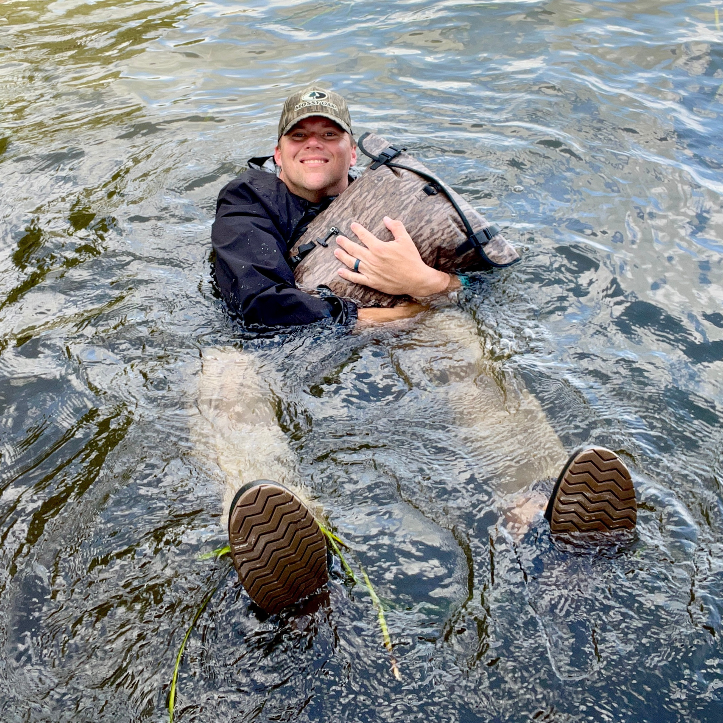 Waterproof floating dry bag worn with shoulder straps in sage green roll-top style