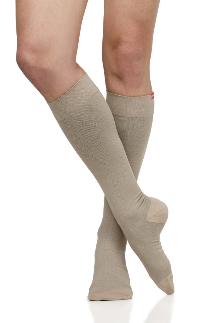 Cashew compression socks on legs, full-length with smooth graduated knit