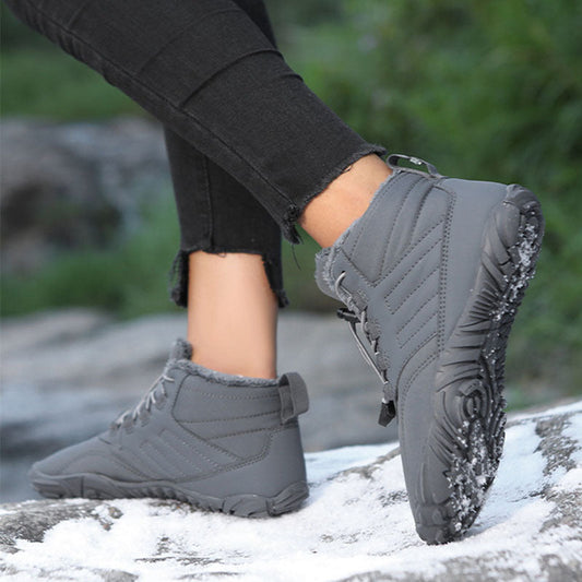 Gray winter slip-on boots with lace-up front and rugged sole, worn with dark pants.