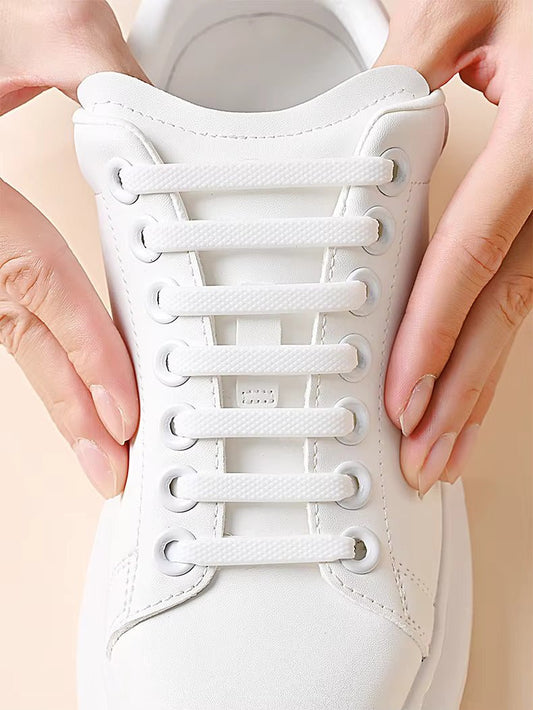 Close-up of a white sneaker laced with elastic shoelace bands held by hands