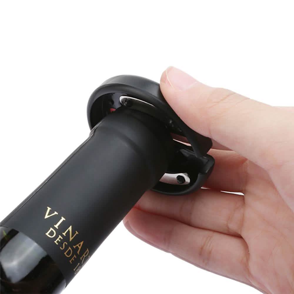 Hand holding a black electric wine bottle opener with side switch visible