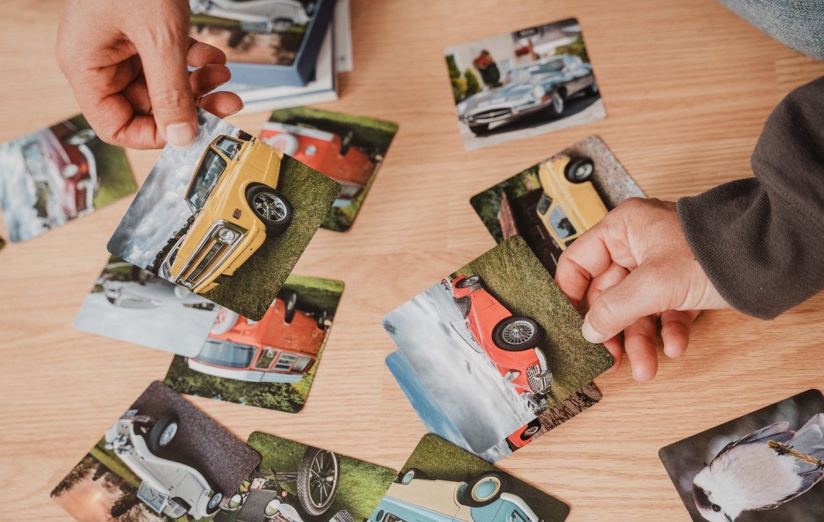 Hands selecting from a spread of car and animal themed activity cards