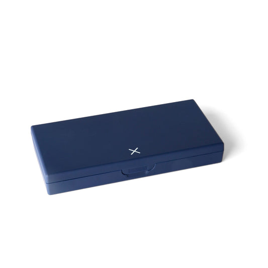 Navy blue pill box closed with small X mark on top