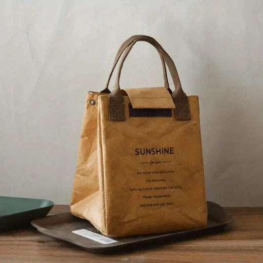 Brown insulated paper bento bag with carry handles and front flap pocket, front view