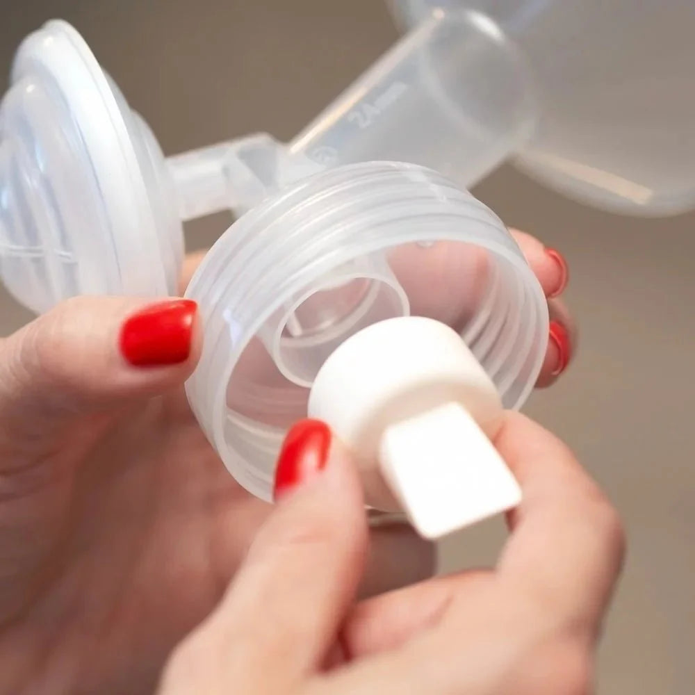 Duckbill valve close-up held by hand, white valve with connector tip