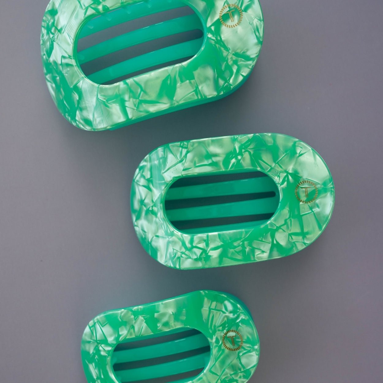 Mint green translucent flat round hair clips, three pieces shown