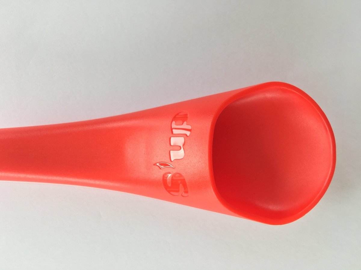 Close-up of red S'up spoon end with embossed 'S'up' logo on the handle