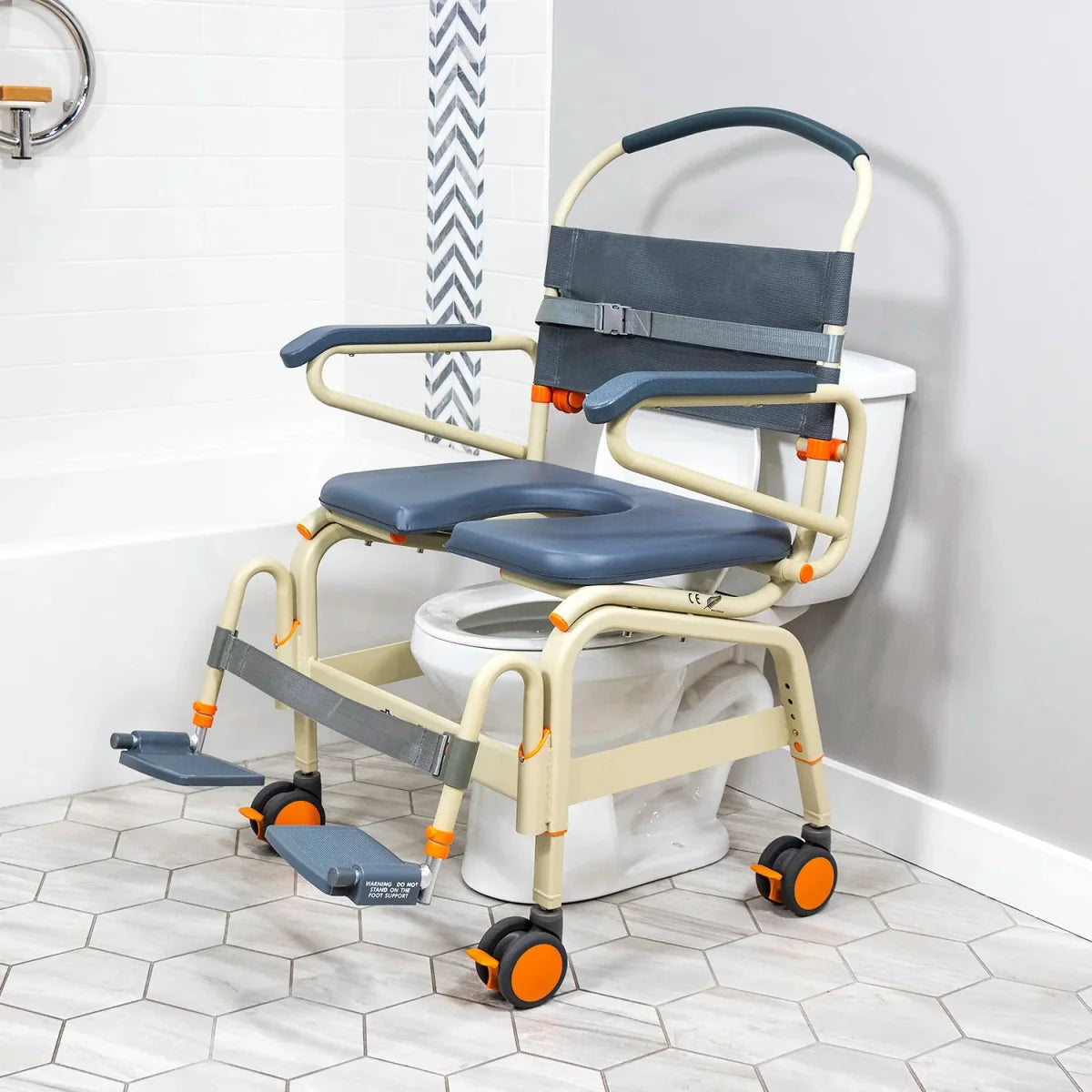 Wide roll-in shower chair with padded blue seat and back, beige frame, armrests and wheels