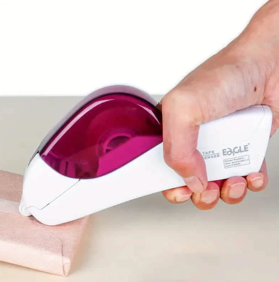 Hand using a tape dispenser with a visible brand logo on a neutral background