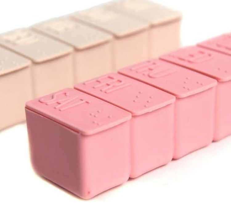 Pink pill organizer with Braille for each day of the week