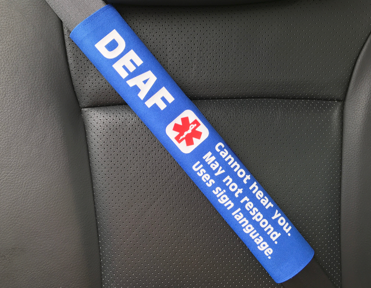 Blue seat belt cover with 'DEAF' and medical symbol on a car seat