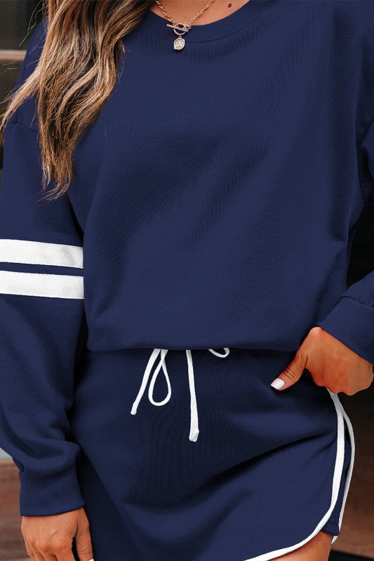 Navy sweatshirt with white stripe sleeve band and drawstring mini skirt waist.