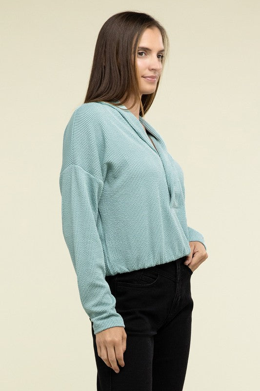 Teal textured pullover top, side profile, collared V-neck and two-button placket