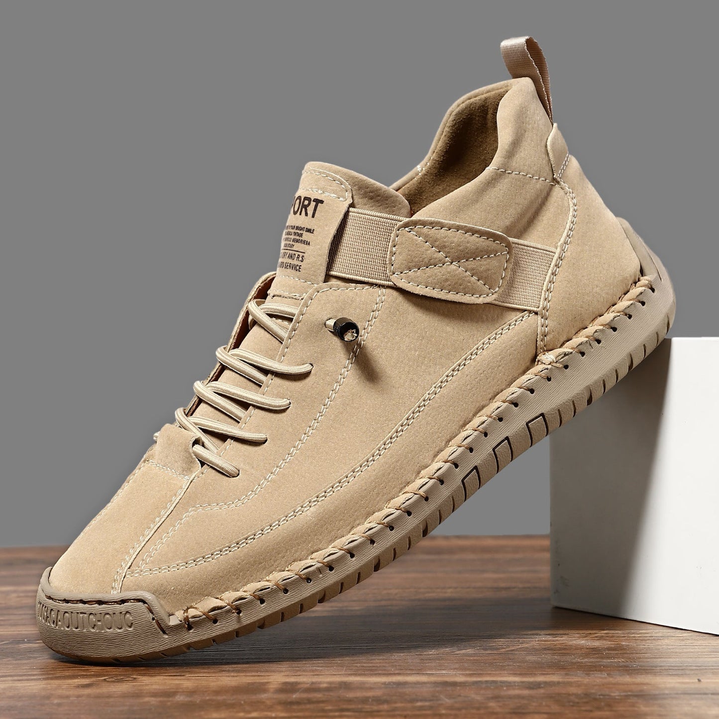 Casual leather boots in tan with lace-up front, side strap, and stitched rubber tread sole.