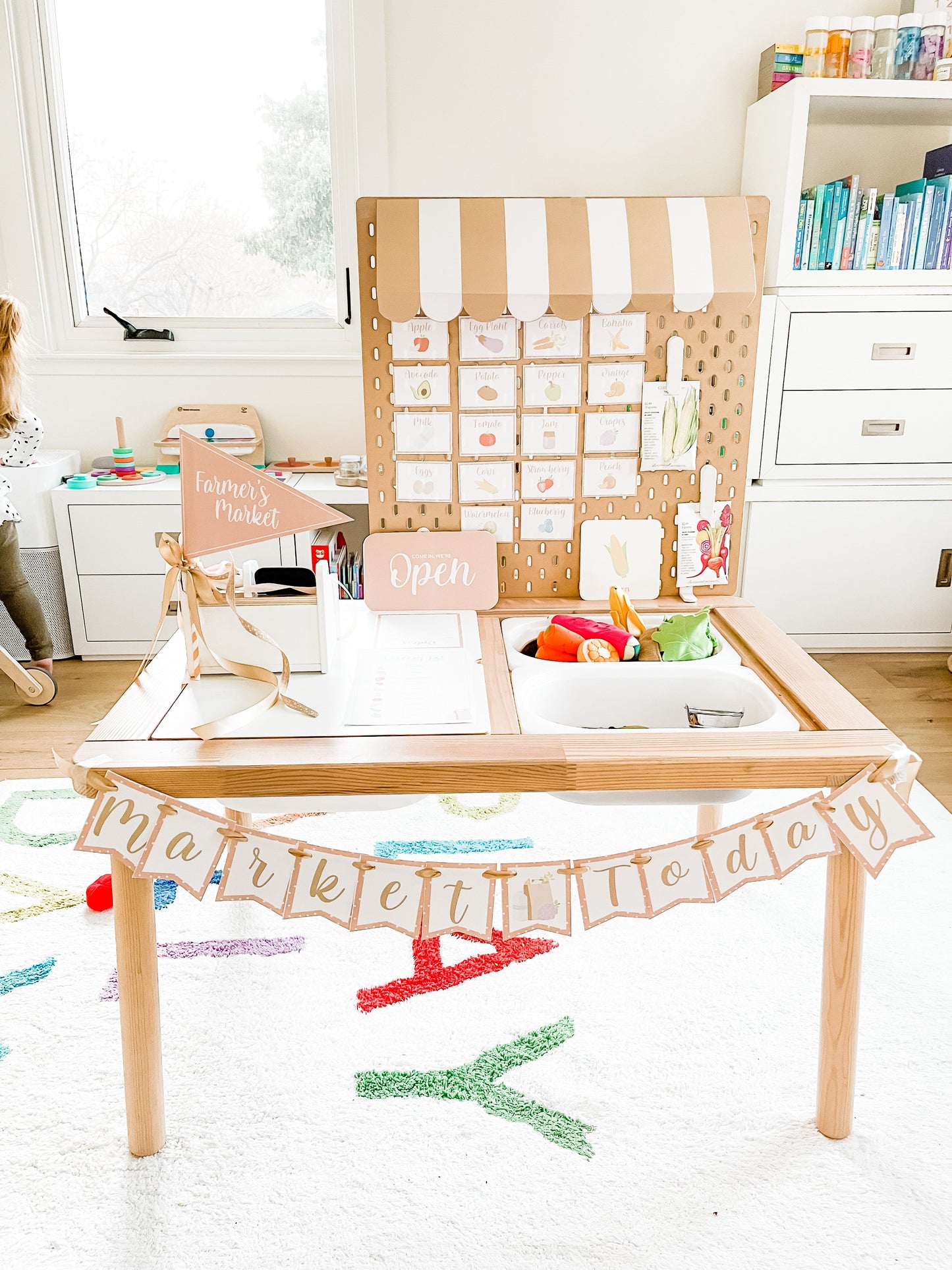 Kids market play table with open sign and pegboard-style food card display