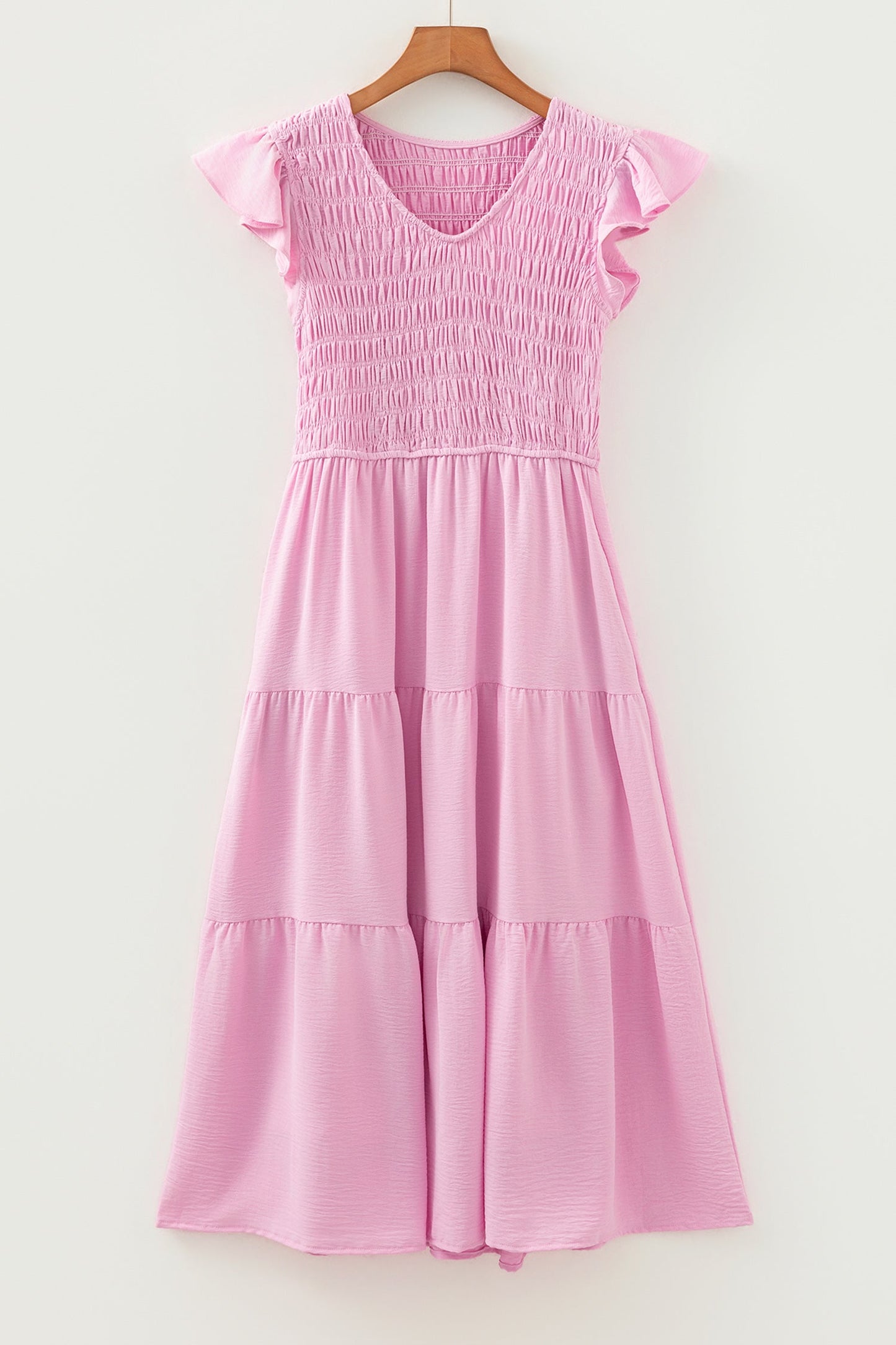 Pink tiered midi dress on hanger with smocked bodice and flutter cap sleeves