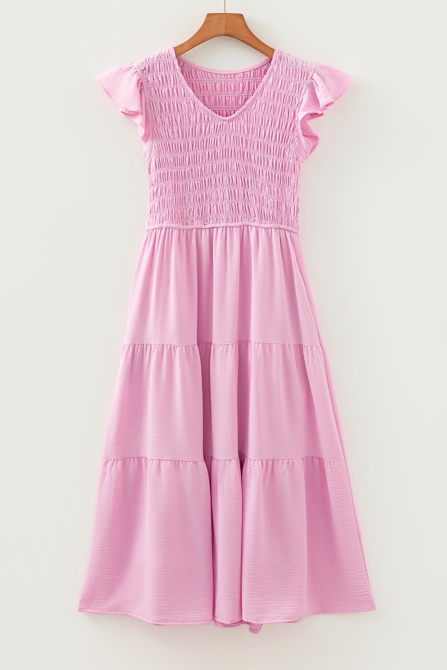 Pink tiered midi dress on hanger with smocked bodice and flutter cap sleeves