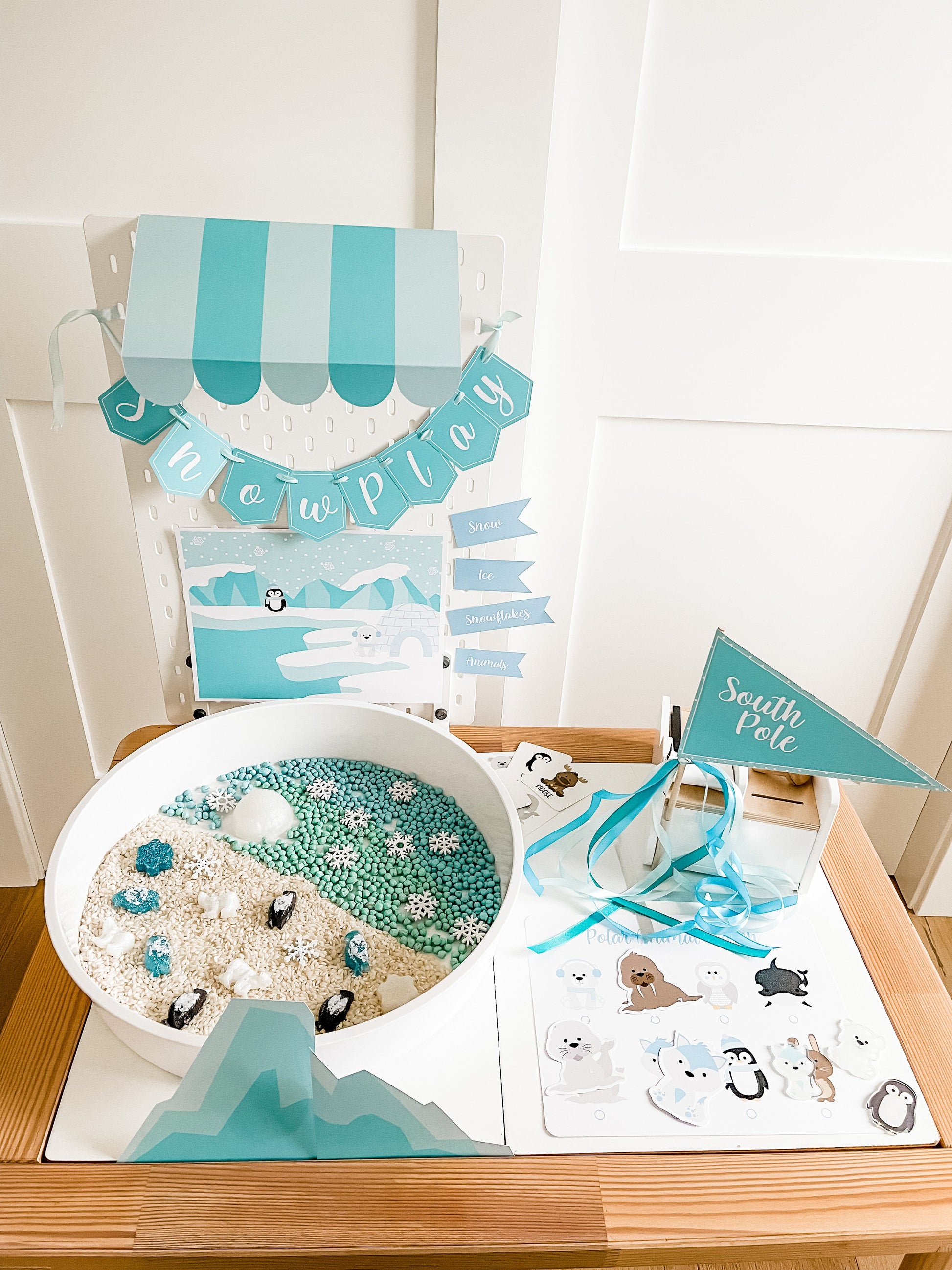 Polar animal sensory play bin with circular tray, blue ice-theme cards, and animal cutouts
