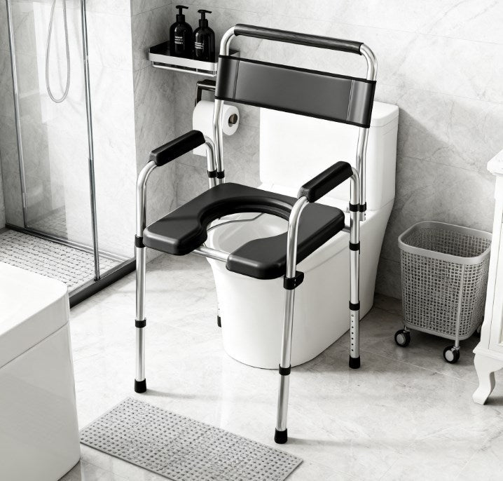 Adjustable commode chair with black seat and armrests beside a toilet