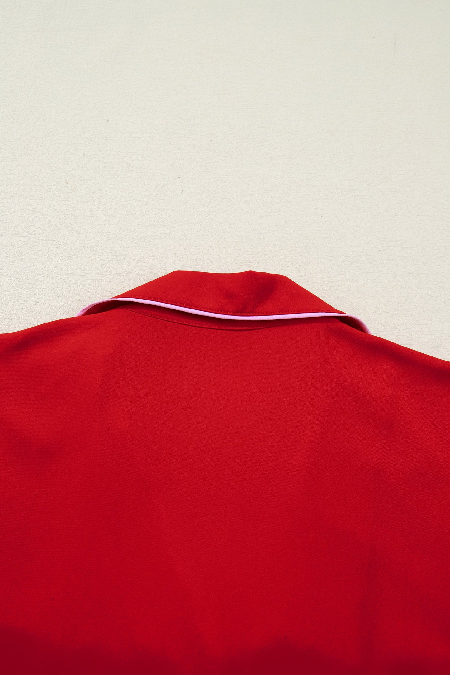 Red pajama top with curved neckline and white trim edge