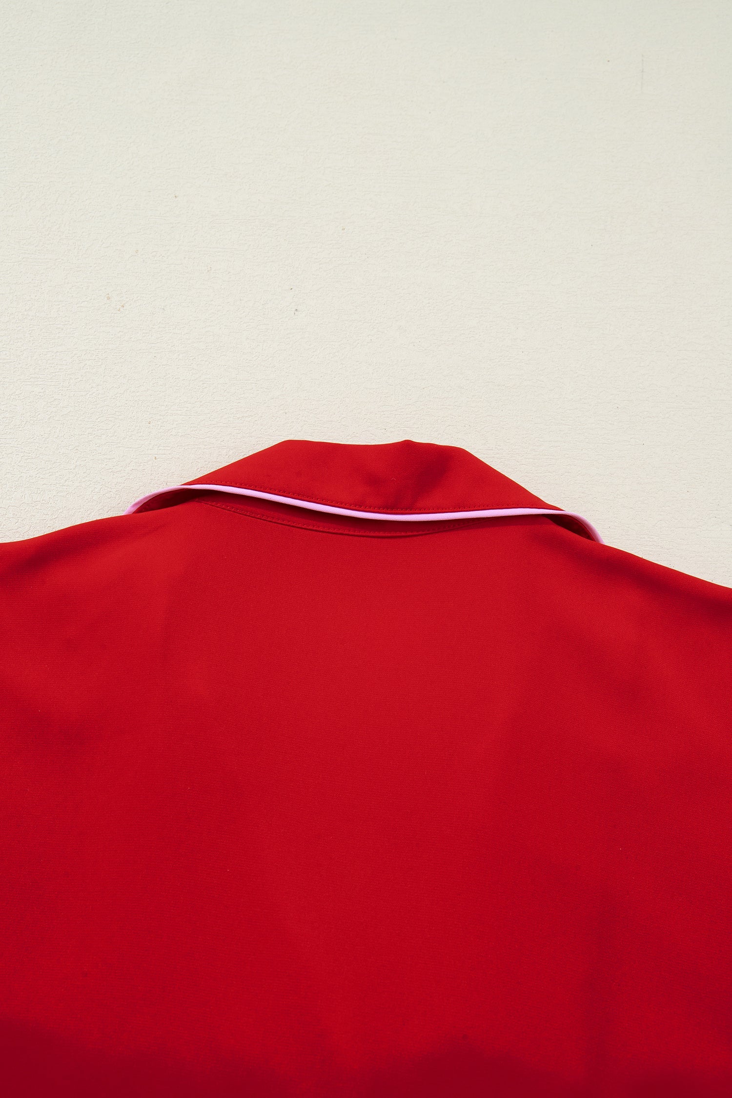 Red pajama top with curved neckline and white trim edge