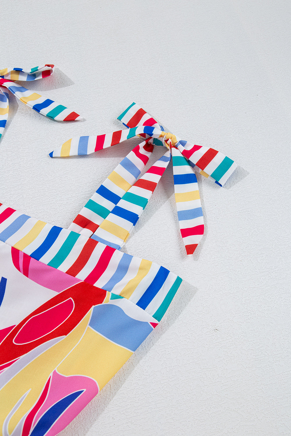 Close-up: multicolor striped shoulder ties with matching striped trim on sundress