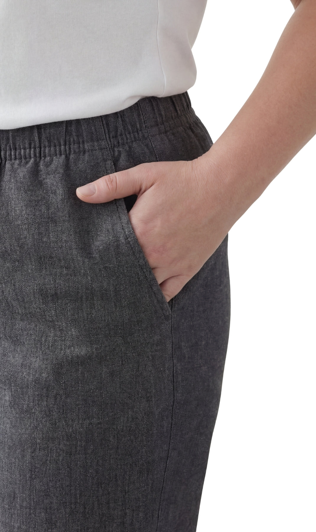 Person wearing dark gray pants with a white background