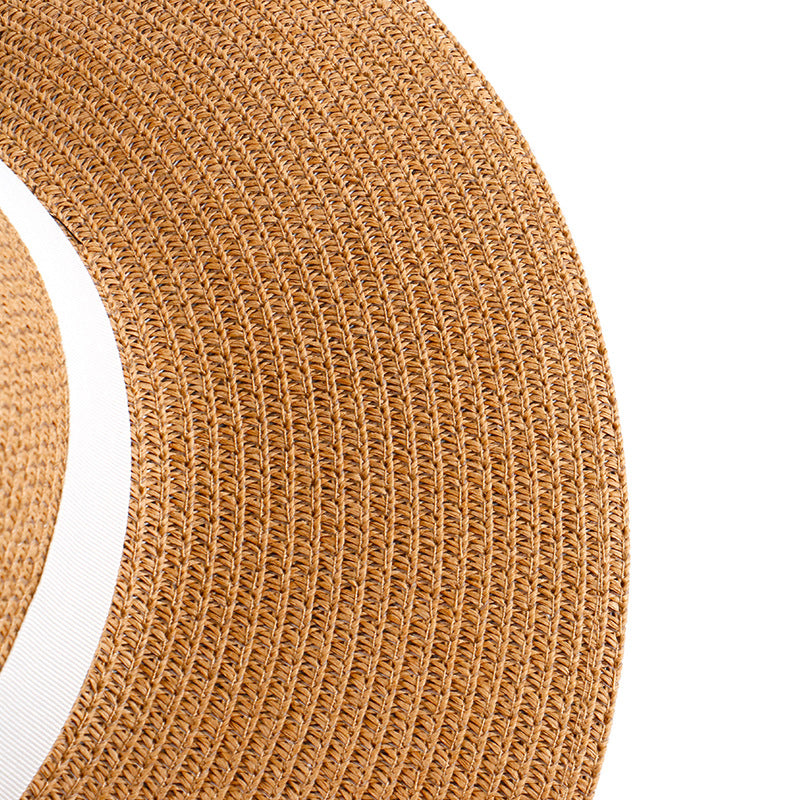 Khaki straw hat brim close-up with textured weave and white band
