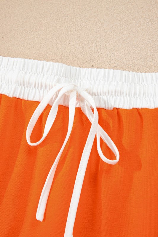 Orange mini skirt with white elastic waistband and drawstring ties