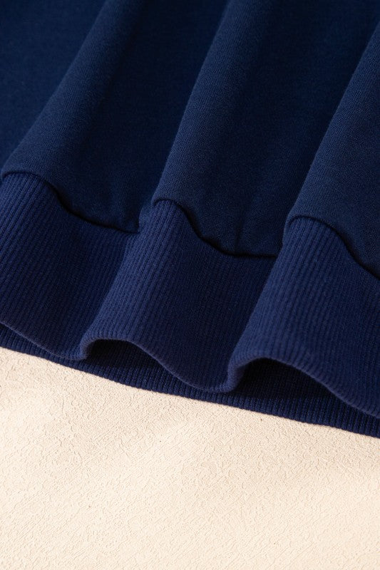 Navy pullover hem with ribbed knit cuffs and textured fabric