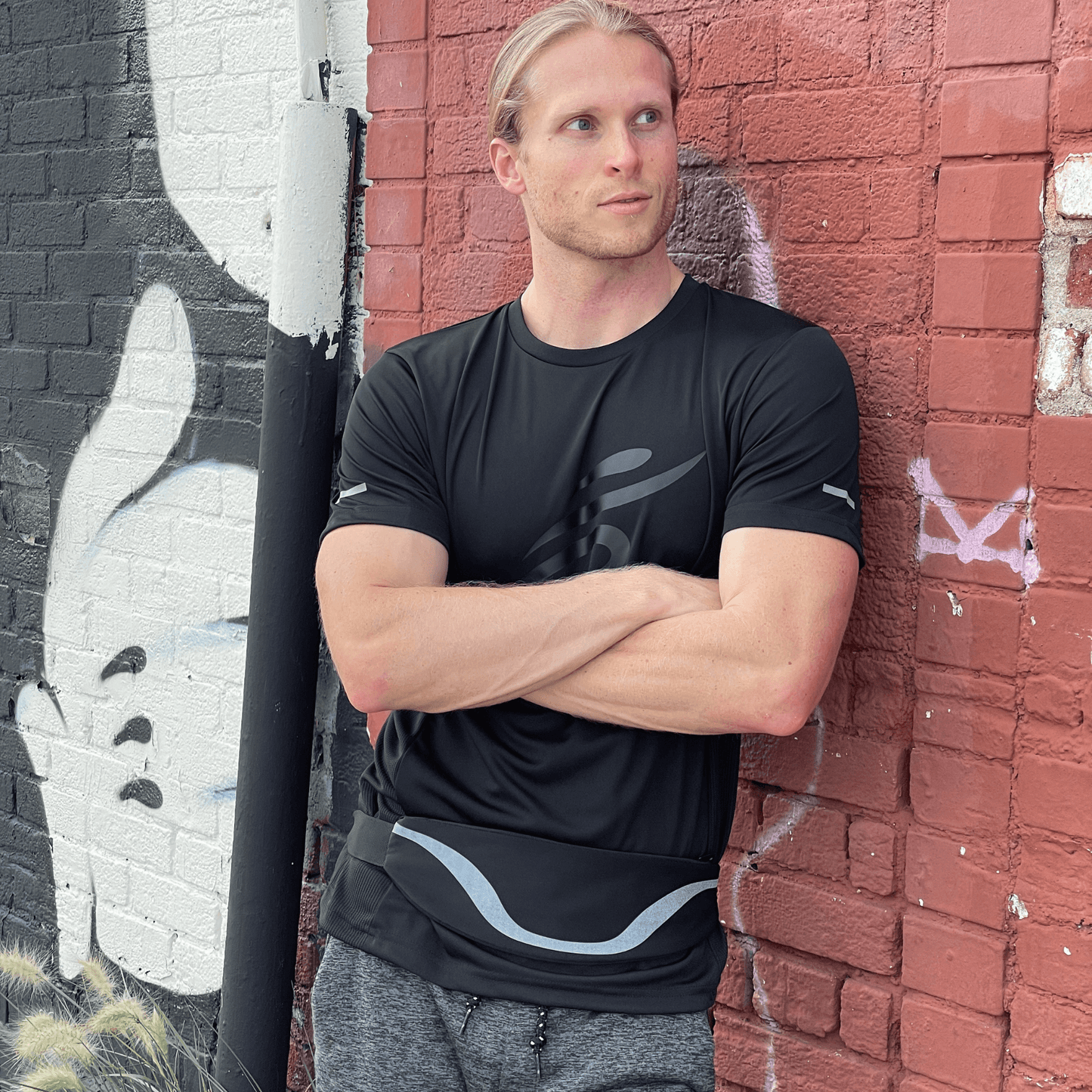 Water-resistant sport waist pack with dark reflective stripe, worn around the waist.