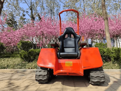 Orange all-terrain electric wheelchair with black seat and rugged tread track chassis